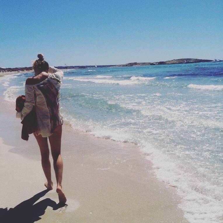 Blonde girl walking on a beach in Formentera