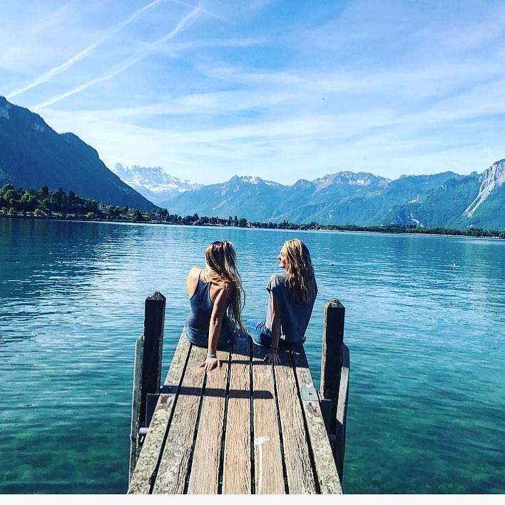 Two girls sitting on a pier on Lake Geneva